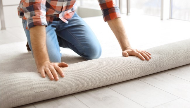 Man rolling carpet for installation | Right Carpet & Interiors